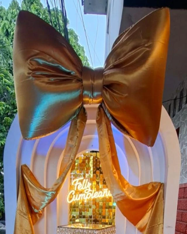 Arco blanco iluminado con gran lazo dorado