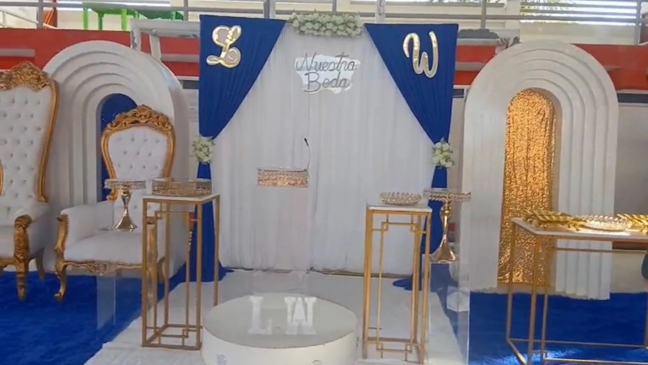 Montaje de boda azul y blanco con mesas, arcos y detalles dorados