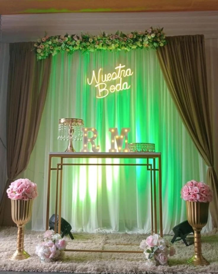 Montaje de boda con flores, cortinas y mesa decorativa