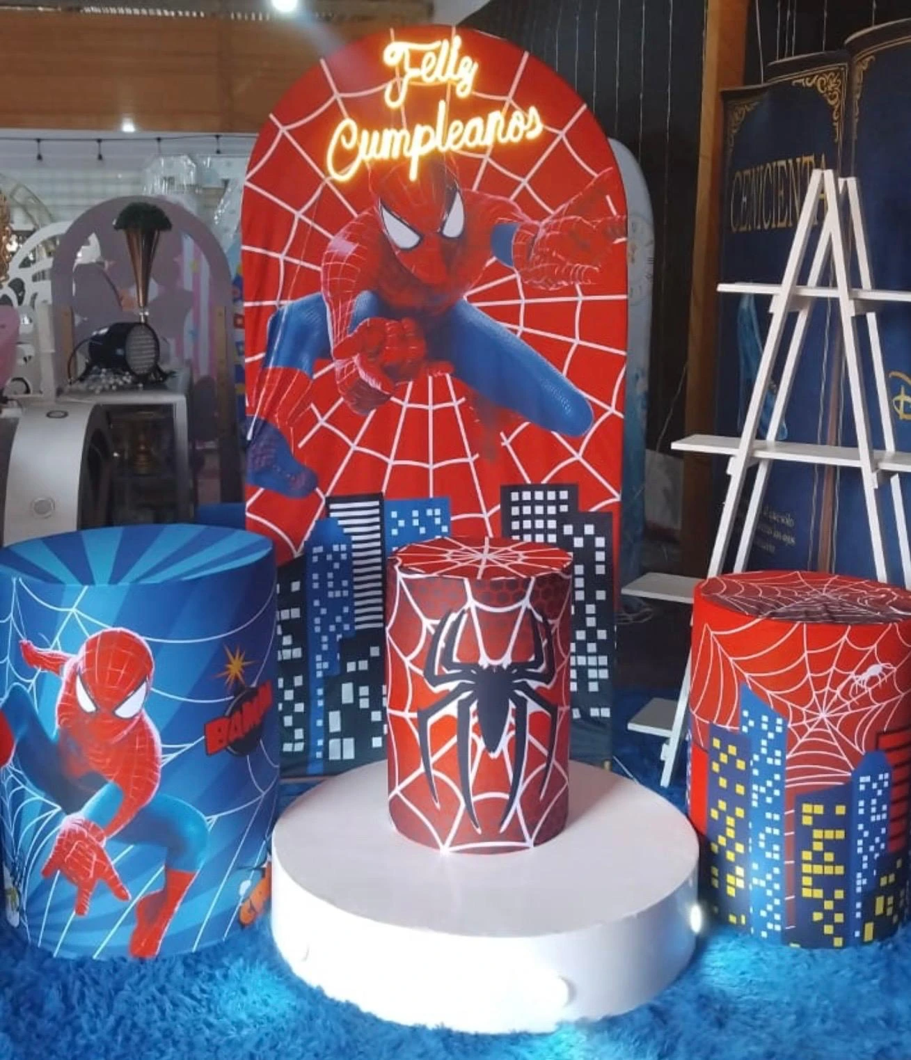 Escenario temático rojo y azul con panel arqueado y cilindros decorativos
