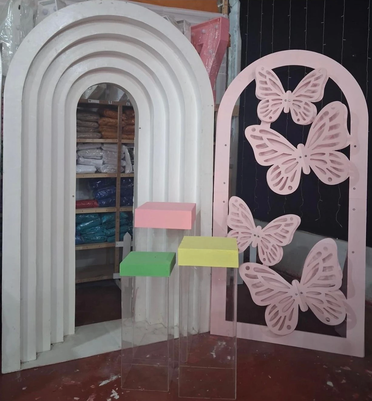 Arcos blancos, panel de mariposas y bases transparentes disponibles para ambientación