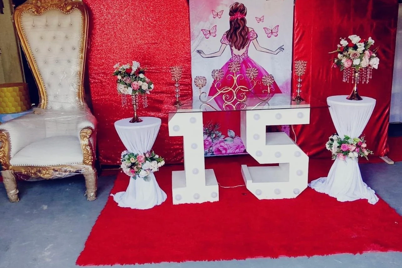 Montaje rojo para celebración de quince años con sillón y flores