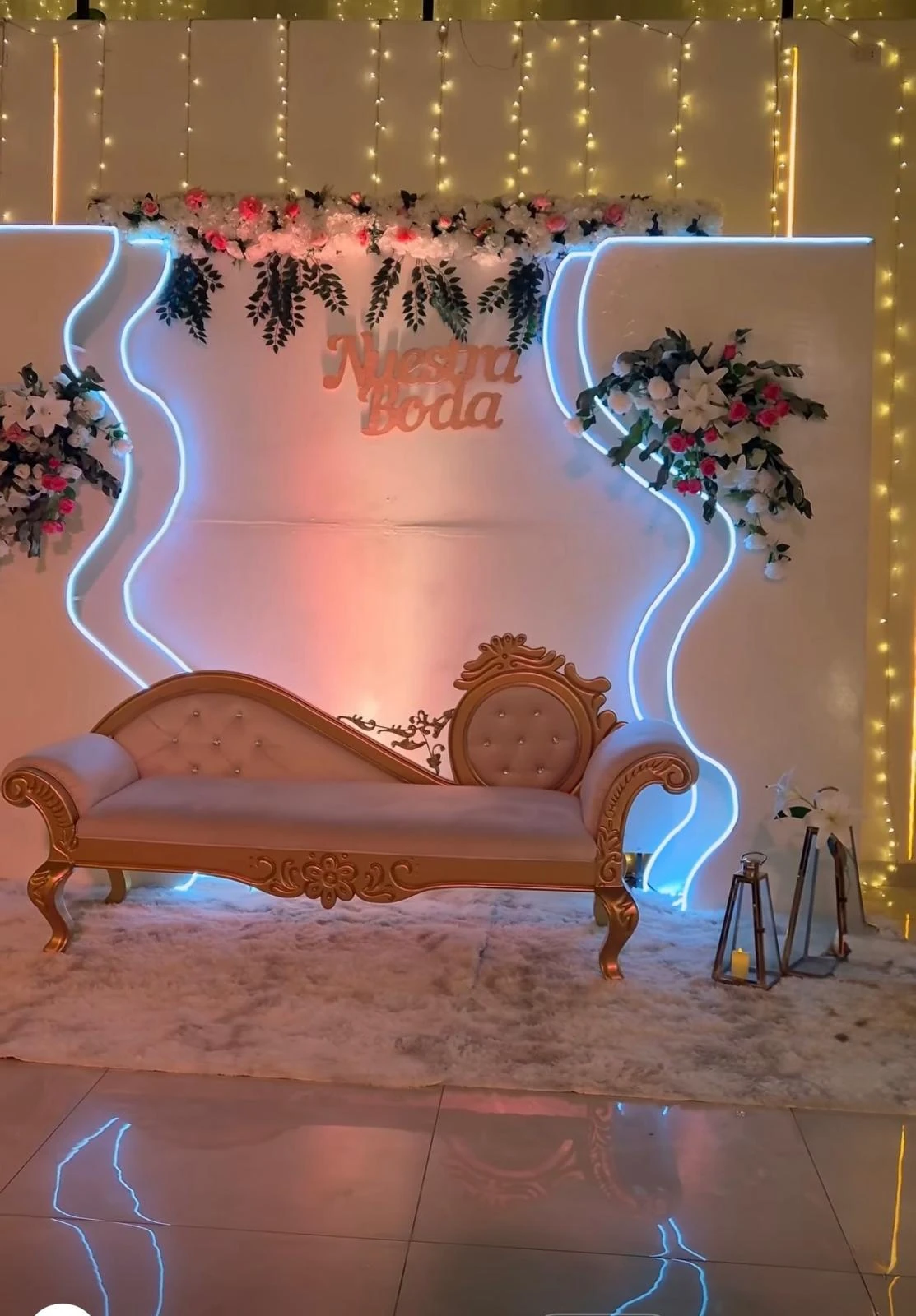 Sofá clásico frente a un fondo iluminado con flores